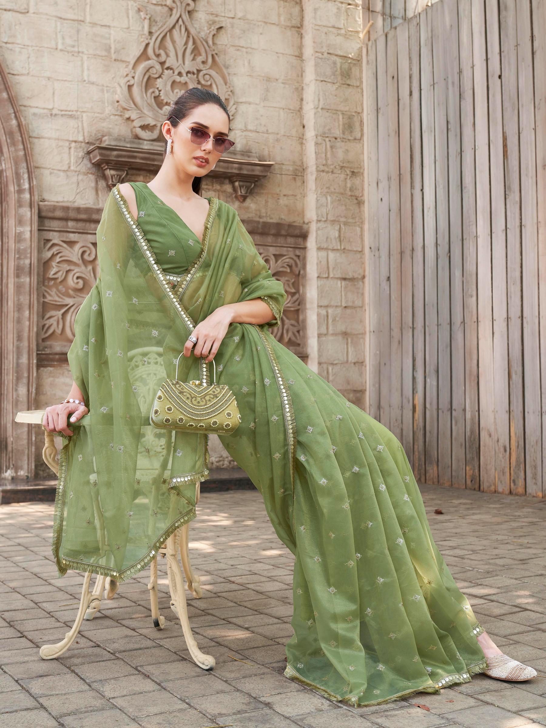 Green colored shimmer net saree with sequinned butti and embroidered border
